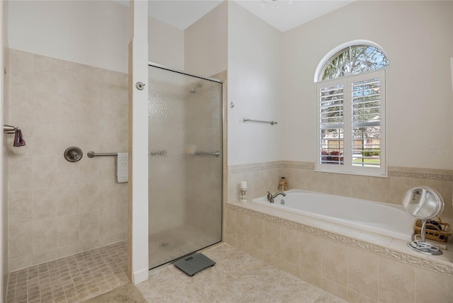 full bath with a wealth of natural light, tile patterned flooring, a garden tub, and a shower stall