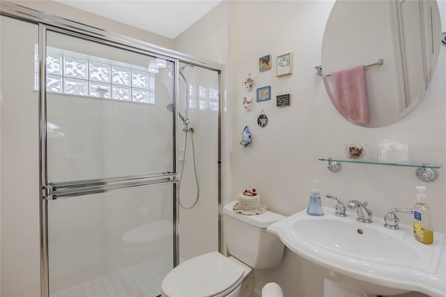 full bathroom featuring a stall shower, a sink, and toilet