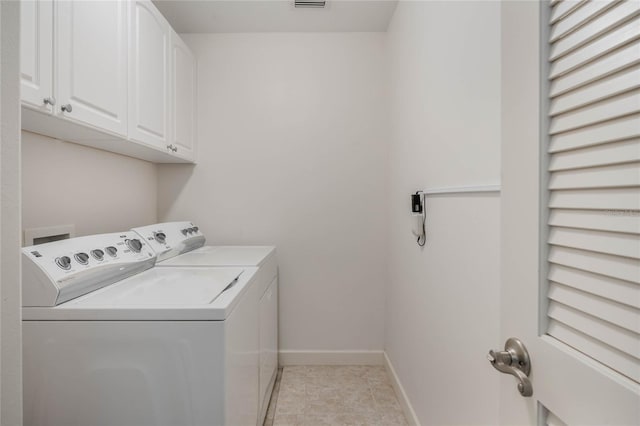 clothes washing area with light tile patterned floors, cabinet space, visible vents, washer and dryer, and baseboards