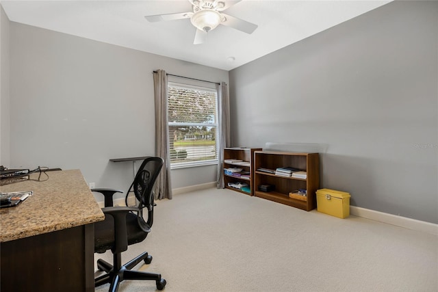 office space with baseboards, a ceiling fan, and light colored carpet