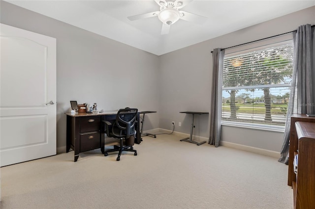 office space with baseboards, ceiling fan, and light colored carpet