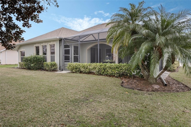 exterior space featuring a lanai, a yard, and stucco siding