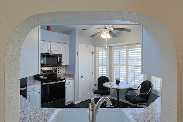 kitchen with arched walkways, a sink, a ceiling fan, and black electric range