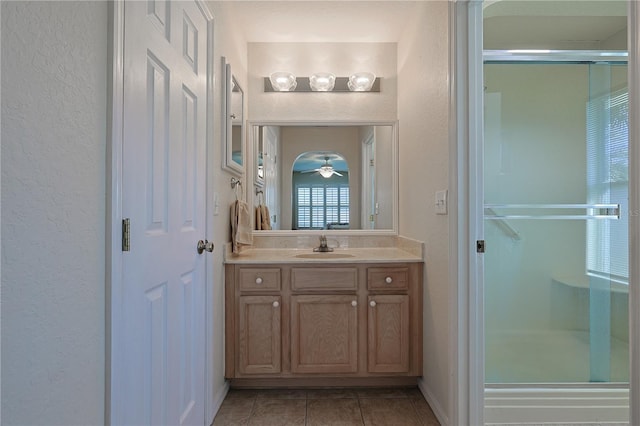bathroom with vanity, tile patterned floors, a textured wall, and a stall shower