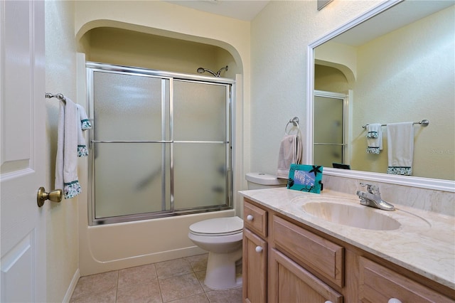 bathroom with toilet, tile patterned floors, enclosed tub / shower combo, and vanity