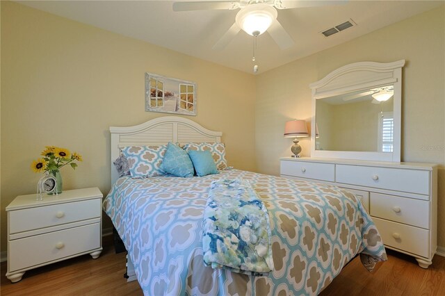 bedroom with visible vents, a ceiling fan, and wood finished floors