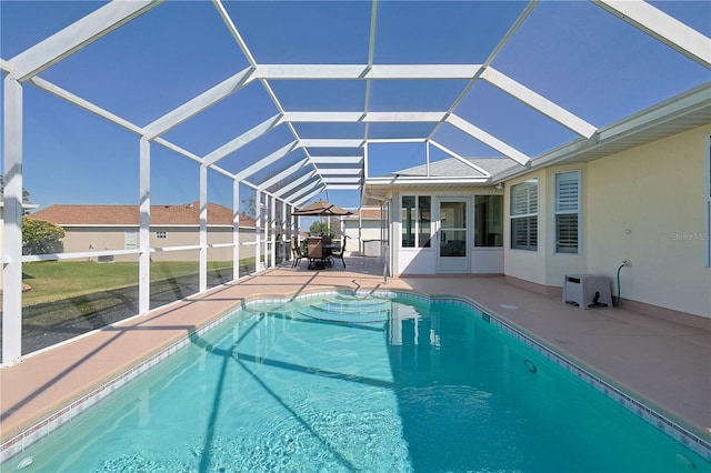 view of swimming pool with glass enclosure, a patio, and a fenced in pool