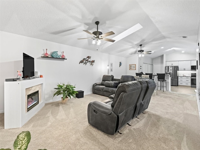 interior space featuring a ceiling fan, light colored carpet, a premium fireplace, vaulted ceiling, and a textured ceiling