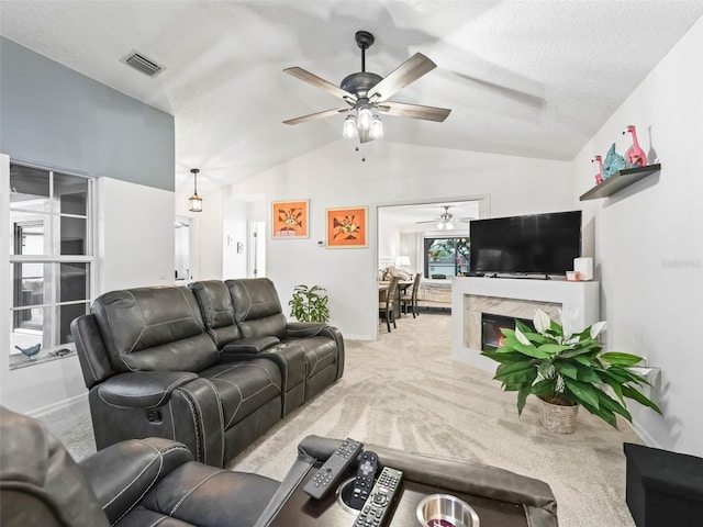 living area with lofted ceiling, visible vents, light carpet, a textured ceiling, and baseboards