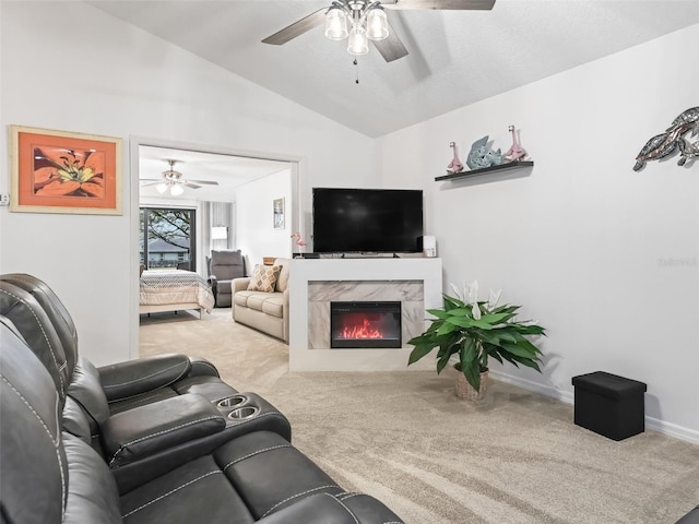 living room with baseboards, lofted ceiling, ceiling fan, carpet, and a high end fireplace