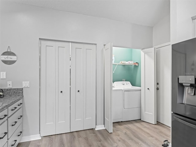 washroom featuring laundry area, washer and clothes dryer, and light wood finished floors