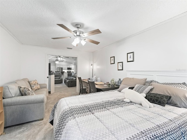 bedroom with crown molding, a ceiling fan, a textured ceiling, and light colored carpet