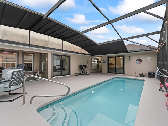 pool featuring glass enclosure and a patio area