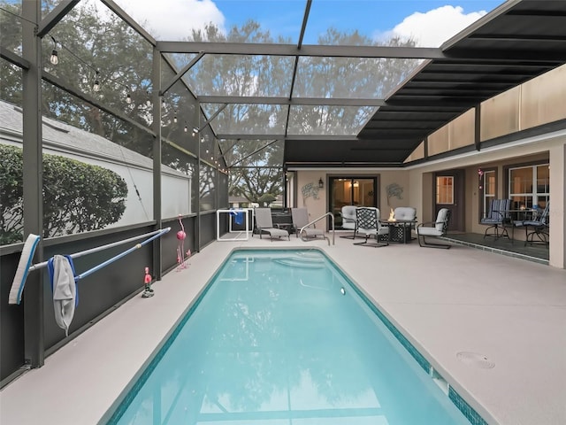 outdoor pool featuring glass enclosure and a patio area