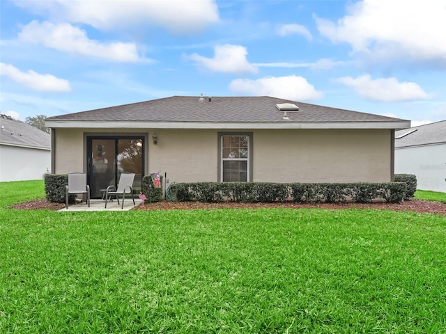 back of property featuring a yard, a shingled roof, a patio, and stucco siding