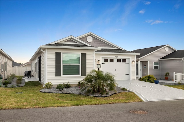 view of front facade with a front lawn, concrete driveway, a garage, and fence