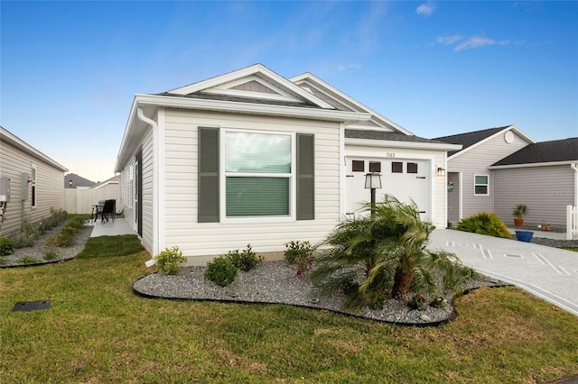 view of front of property featuring fence, an attached garage, concrete driveway, a front lawn, and a patio area