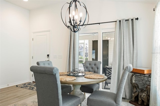 dining area featuring wood finished floors, baseboards, breakfast area, and a chandelier