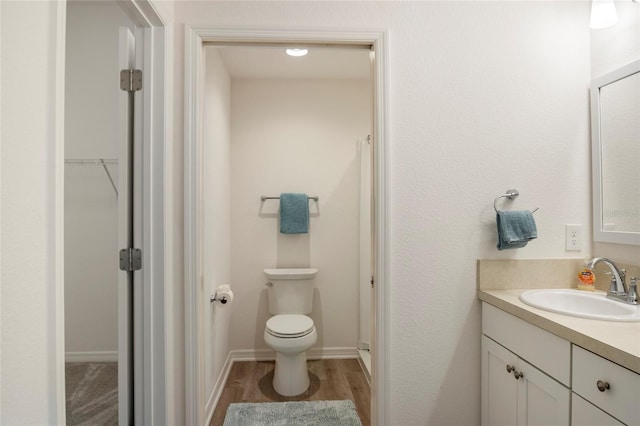 full bath with vanity, toilet, wood finished floors, and baseboards