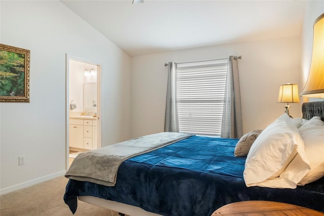 carpeted bedroom with connected bathroom, baseboards, and vaulted ceiling