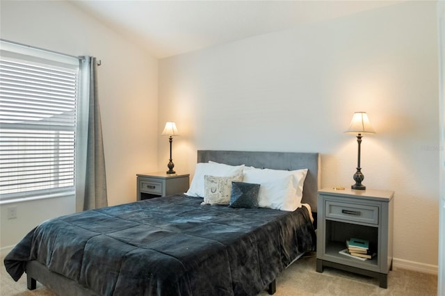 carpeted bedroom featuring baseboards and vaulted ceiling