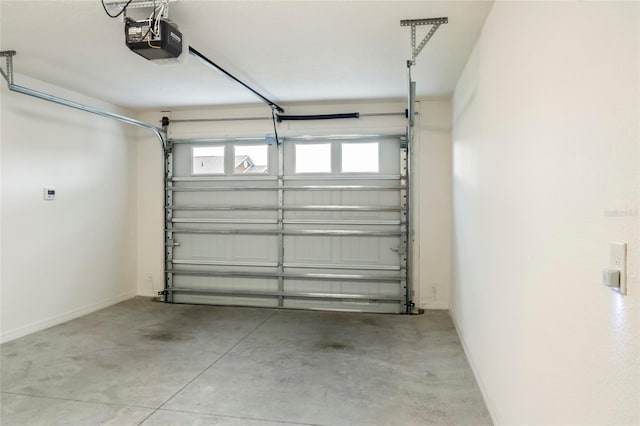 garage featuring a garage door opener and baseboards