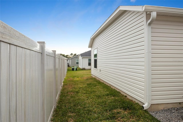 view of side of property with a yard and fence