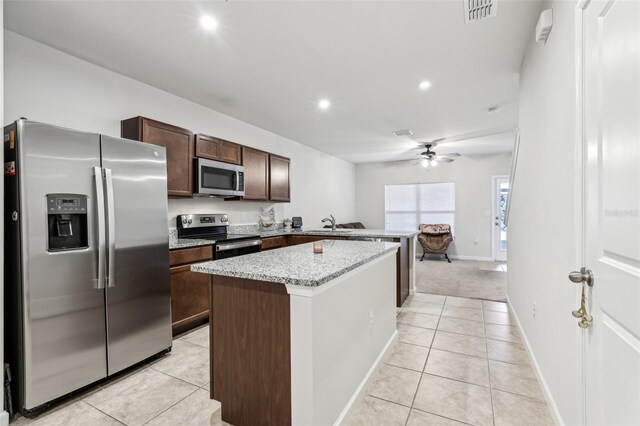 255 Blueberry Ln, Davenport, FL 33837 - kitchen with a ceiling fan, dark brown cabinets, light tile patterned floors, appliances with stainless steel finishes, and visible vents