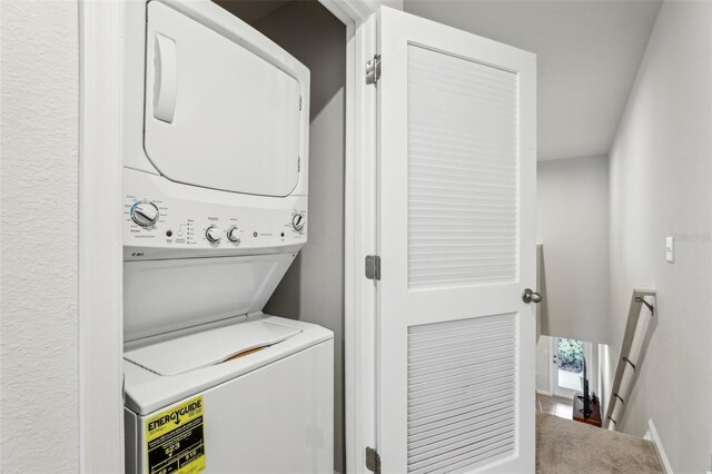 255 Blueberry Ln, Davenport, FL 33837 - washroom with baseboards, stacked washer / dryer, and laundry area