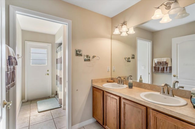 full bathroom featuring double vanity, baseboards, a sink, and tile patterned floors