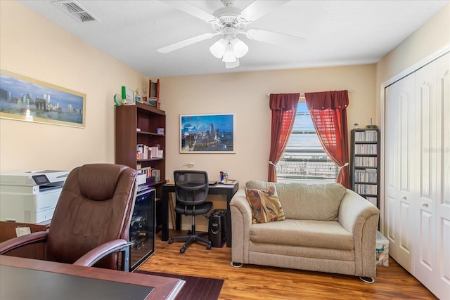 home office featuring visible vents, ceiling fan, and wood finished floors