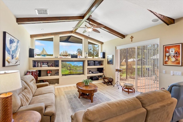 living room featuring a ceiling fan, visible vents, lofted ceiling with beams, and wood finished floors