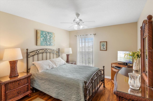 bedroom with ceiling fan, wood finished floors, and baseboards