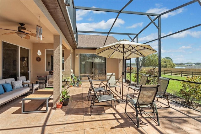 view of patio / terrace with an outdoor hangout area, glass enclosure, and a ceiling fan