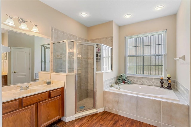 full bathroom featuring a bath, a shower stall, wood finished floors, and vanity