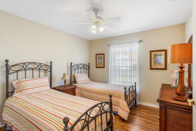 bedroom with ceiling fan, wood finished floors, and baseboards