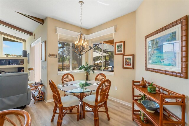 dining area with beamed ceiling, plenty of natural light, and wood finished floors