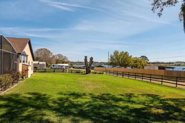 view of yard featuring fence and a lanai