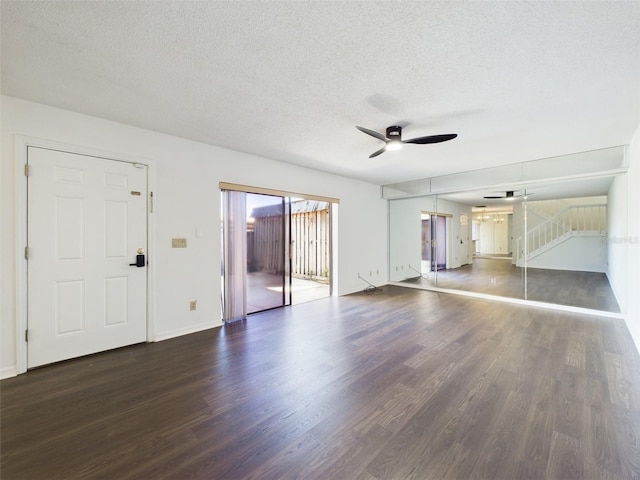 unfurnished living room featuring baseboards, a textured ceiling, a ceiling fan, and dark wood-style flooring