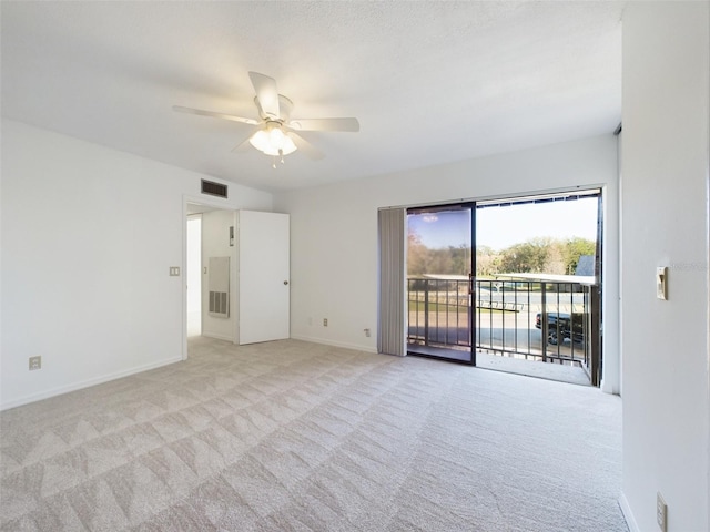 empty room with light carpet, ceiling fan, visible vents, and baseboards