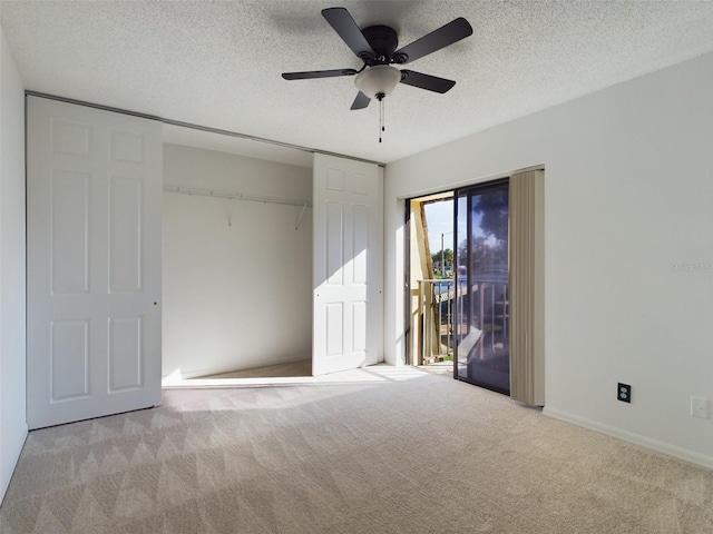 unfurnished bedroom with access to exterior, a closet, light carpet, ceiling fan, and a textured ceiling