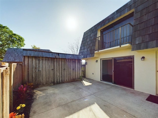 view of patio featuring fence and a balcony