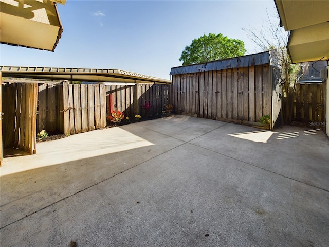 view of patio / terrace with an outbuilding, a fenced backyard, and a storage shed