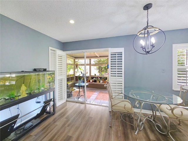 6106 Kittiwake Dr, Lakeland, FL 33809 - dining area with a notable chandelier, a textured ceiling, baseboards, and wood finished floors