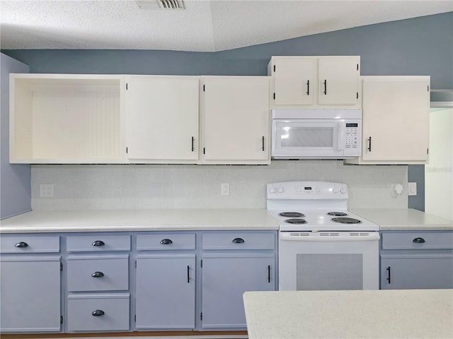 6106 Kittiwake Dr, Lakeland, FL 33809 - kitchen with light countertops, vaulted ceiling, decorative backsplash, white cabinets, and white appliances