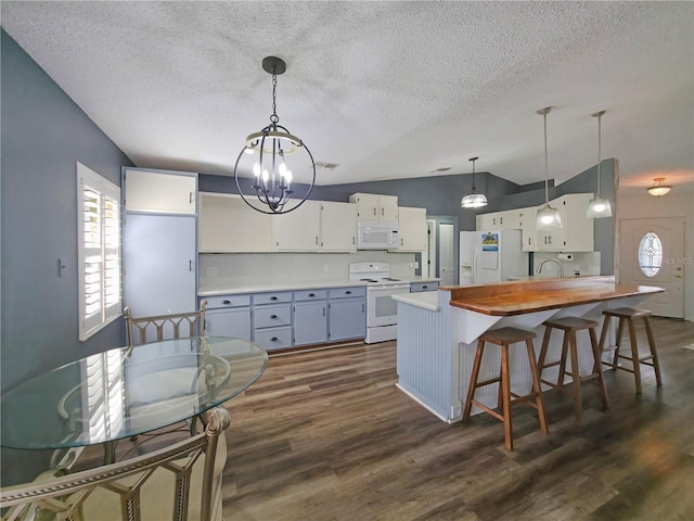 6106 Kittiwake Dr, Lakeland, FL 33809 - kitchen with an inviting chandelier, white appliances, a wealth of natural light, and vaulted ceiling