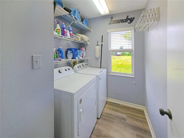 6106 Kittiwake Dr, Lakeland, FL 33809 - washroom with baseboards, laundry area, light wood-style floors, a textured ceiling, and separate washer and dryer