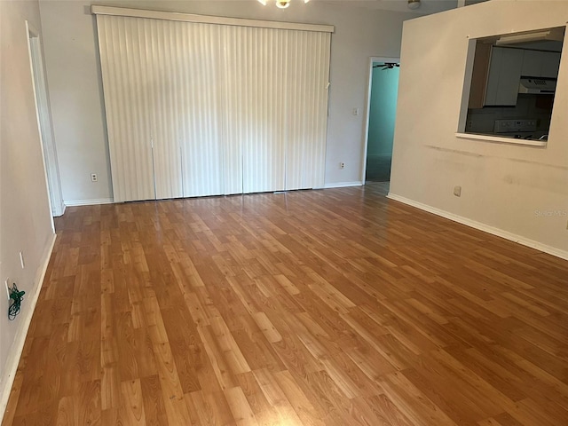 empty room with baseboards and wood finished floors