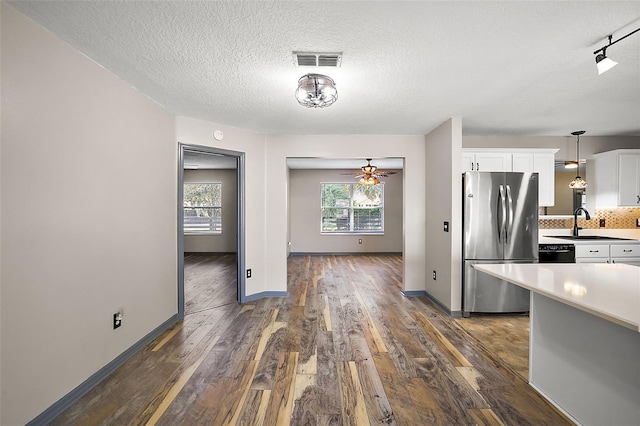 kitchen featuring visible vents, white cabinets, decorative light fixtures, freestanding refrigerator, and light countertops