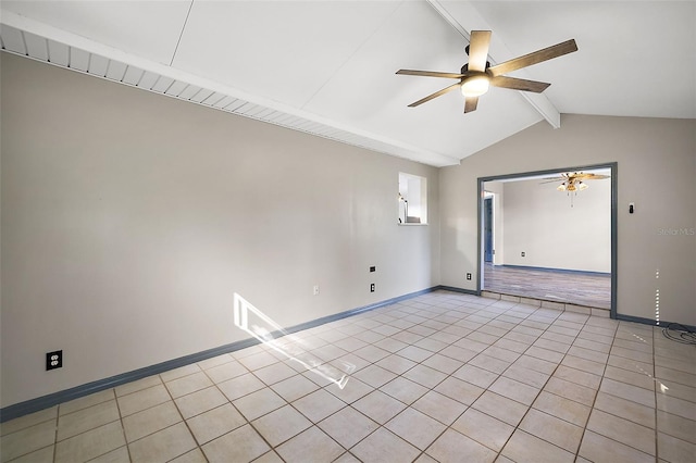 empty room with lofted ceiling with beams, light tile patterned floors, a ceiling fan, and baseboards